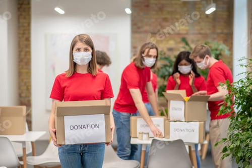 Preview: Volunteers in facial masks working with donations sorting
