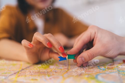 Preview: ?ouple pointing with notice board pins on city map