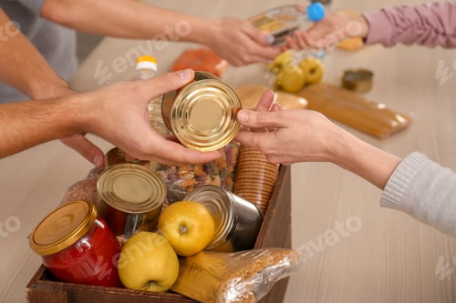 Preview: Volunteers taking food out of donation box on table, closeup