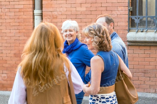 Preview: middle-aged woman looking at her friends as they talk around town