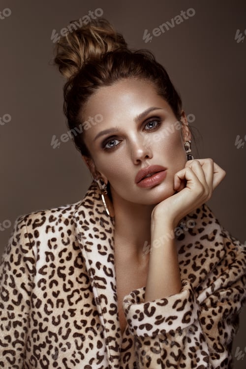 Preview: Beautiful sexy woman in leopard coat, earrings, with classic smokey makeup and a fashion hairstyle