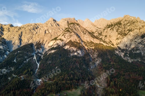 Preview: Aerial view of majestic european Alps mountains covered in evergreen pine forest in autumn