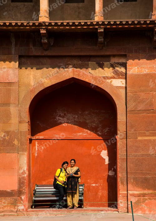 Preview: Young woman tourist with camera at Red Fort, Agra, India.