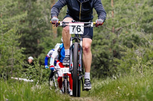 Preview: athlete leader cyclist ahead group of mountain bikers riding cross-country cycling competition
