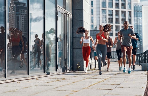 Preview: Full length of people in sports clothing jogging while exercising on the sidewalk outdoors