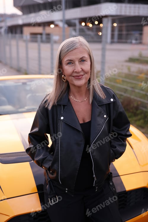 Preview: Stylish senior woman near modern cabriolet outdoors