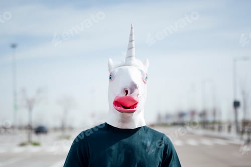 Preview: Man with unicorn mask in a city parking