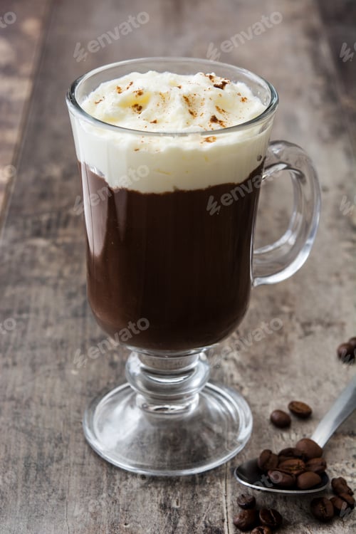 Preview: Irish coffee with whipped cream and cinnamon on rustic wooden table