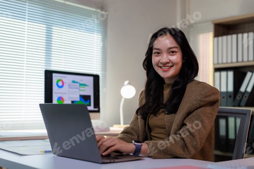 Preview: Young asian businesswoman smiling working on data analysis
