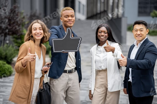Preview: Multiracial business team showing thumb up gesture
