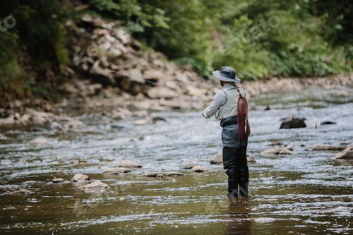 Preview: Fisherman catching trout in river, fly fishing in mountain stream
