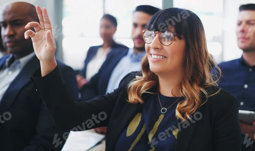 Preview: Shot of a young businesswoman sitting in the audience of a business conference and raising her hand