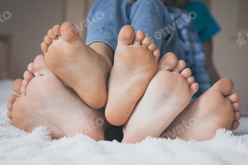 Preview: Happy children sitting on the bed barefoot