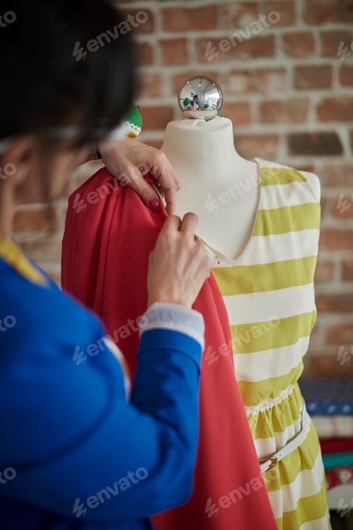 Preview: Rear view of woman in design studio draping fabric onto mannequin