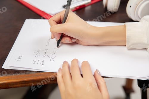 Preview: English courses at home. Close up hands of teacher and student during lesson in interior of living
