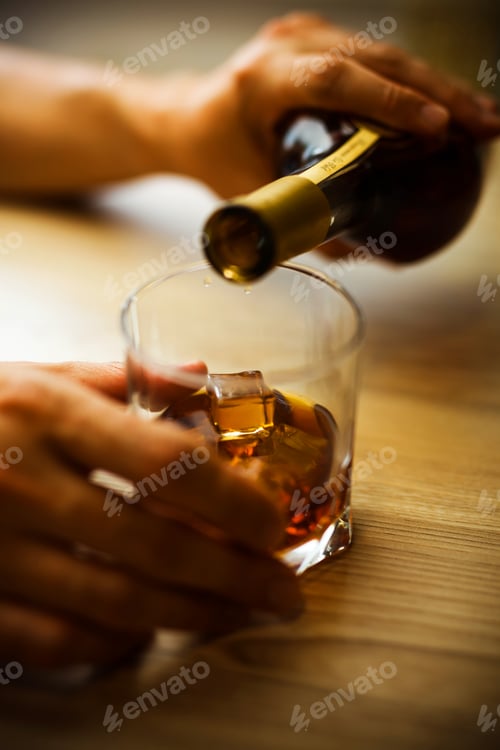 Preview: Hands pour a drink into a glass.
