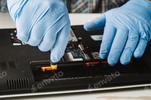 Preview: Man using a screwdriver to disassemble a computer for maintenance