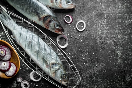 Preview: Raw fish seabass on the grill with chopped onions.