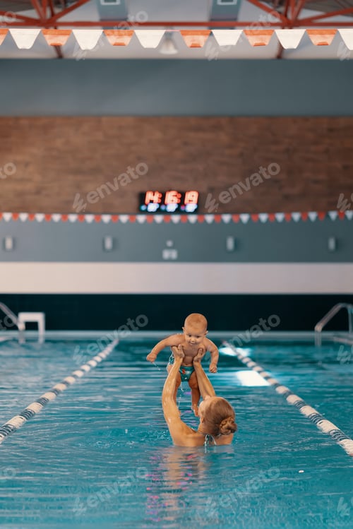 Preview: Mother and little son having fun in a swimming pool