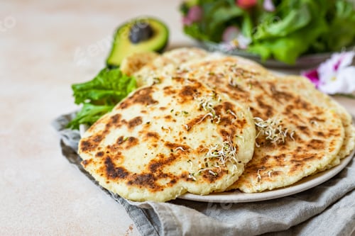 Preview: Homemade chapati or roti flatbread with green salad mix, avocado and sprouts