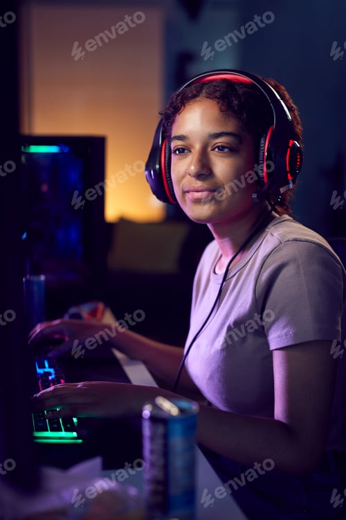 Preview: Teenage Girl With Caffeine Energy Drink Gaming At Home Using Dual Computer Screens At Night
