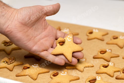 Preview: Person Holding Delicious Festive Star Shaped Cookies