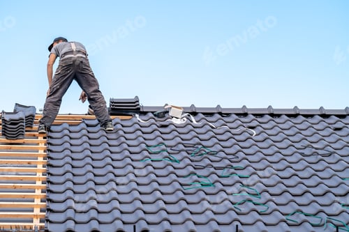 Preview: a craftsman on the roof of a bungalow installs a new roof ceramic covering