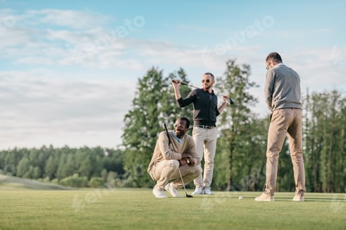 stylish multicultural friends spending time together while playing golf on golf course