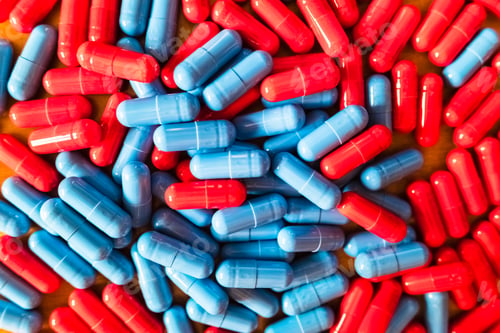 Preview: Detail of a handful of mixed red and blue pills.