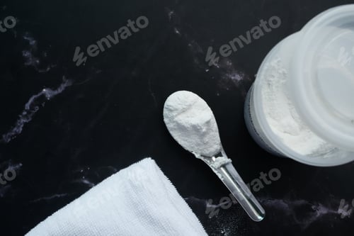 Preview: Washing powder in plastic spoon on black background