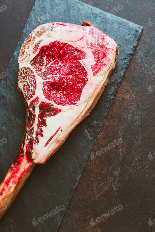 Preview: Top view of raw dry-aged marble beef steak Tomahawk