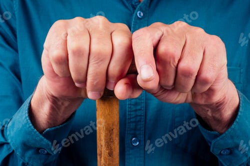 Preview: old man in a casual green shirt holding a cane and posing isolated on white background