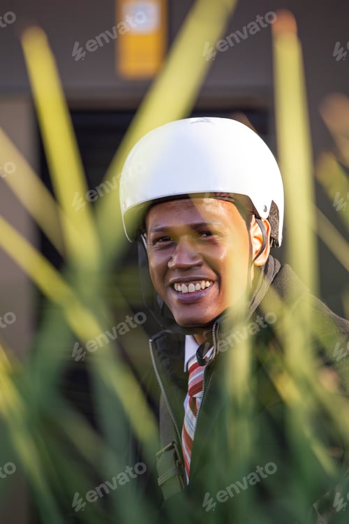 Preview: Latino ethnic businessman with bicycle helmet smiling looking at camera.