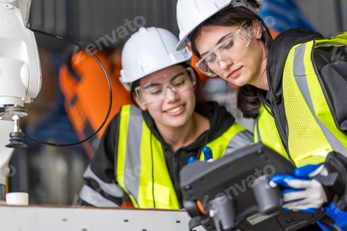 Preview: A team of female engineers meeting to inspect computer-controlled steel welding robots.