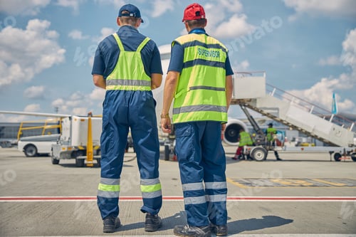 Preview: Two male technicians inspecting the ground equipment
