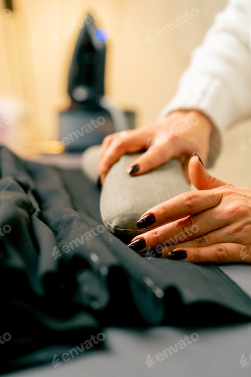 Preview: close-up in a sewing workshop seamstress applies a pillow to cool the fabric