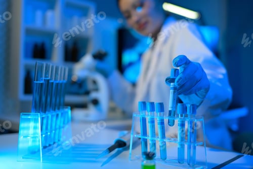 Preview: A woman in a lab coat is holding a syringe