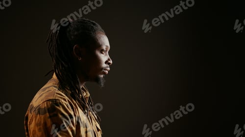 Preview: Joyful male model posing on camera over black background