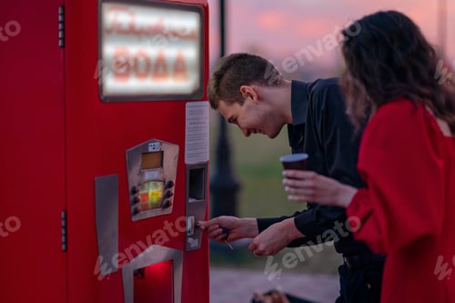 Preview: a couple buys soda water from a vending machine on a hot summer evening