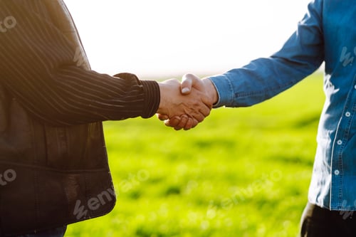 Preview: Handshake two farmer on the background of wheat field at sunset. Concept of agricultural business.