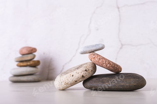 Preview: Balancing structure of smooth sea stones and cairn on table