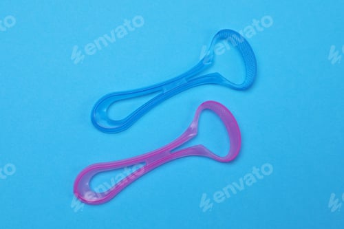 Preview: Tongue cleaners on blue background, flat lay