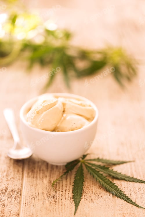 Preview: A hemp leaf is lying on a mock-up jars of ice cream on a table