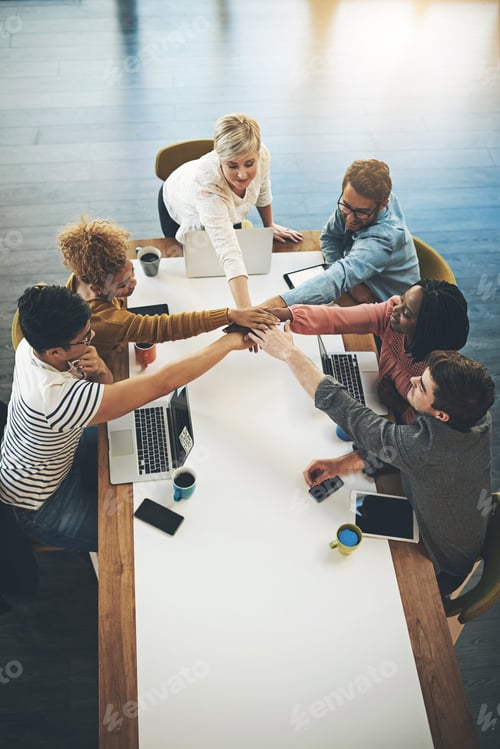 Preview: Shot of a group of businesspeople joining their hands together in unity in an office