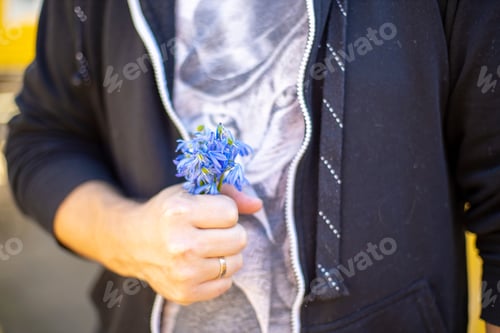 Preview: Faceless man holding bouquet of blue snow flowers in hand to gift it.