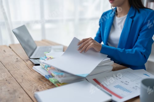 Preview: woman plans a finance and budget audit by reviewing organizing office financial documents