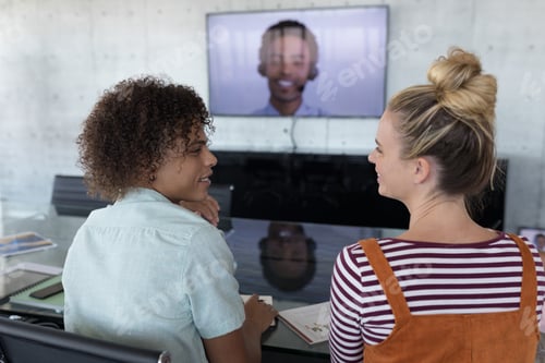 Preview: Young business colleagues interacting with each other in a conference room at office