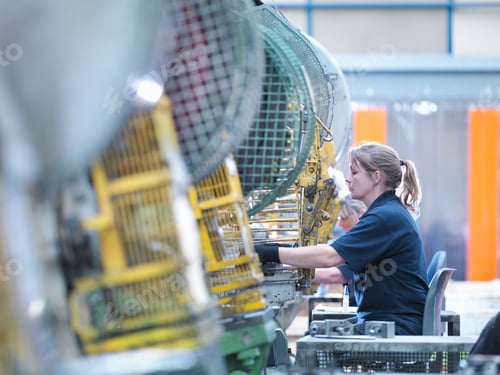 Preview: Female worker operating punch machine in engineering factory