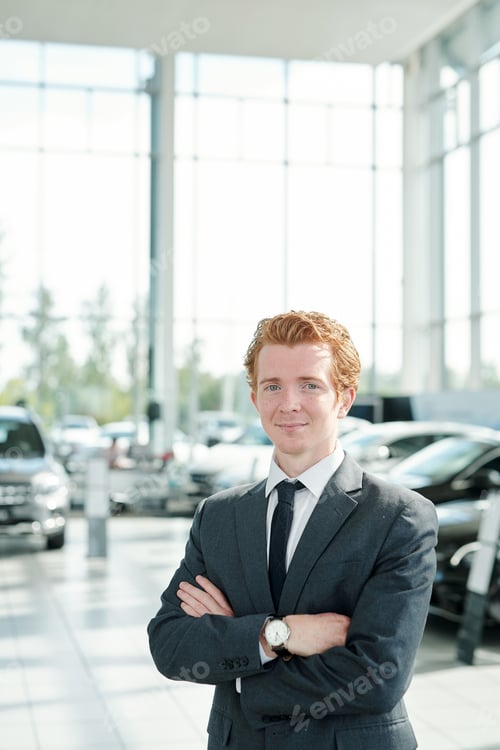 Preview: Successful manager of auto center standing against new cars in front of camera