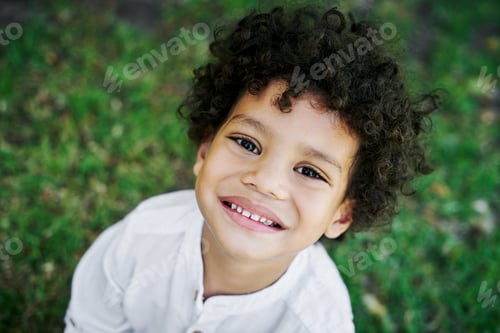 Preview: Smiling Boy with Curly Hair in Outdoor Portrait
